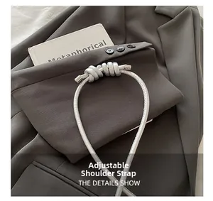Detail of adjustable silver shoulder strap with decorative knots on a metallic handbag