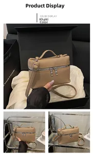 Detail of khaki vanity bag with lychee texture, dual zipper and top handle