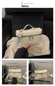 Detailed close-up of cream white crossbody bag with lychee grain texture and top handle