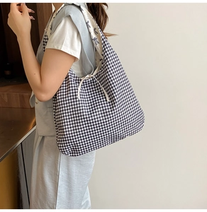 Detail of reversible black gingham tote bag with floral lining and bow tie closure