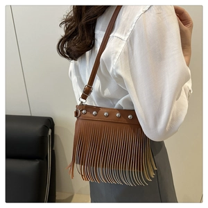Gros plan du sac bandoulière marron avec des rivets argentés et de longues franges