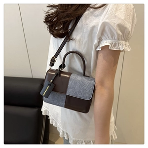 Detail view of contrast stitching and grey tweed texture on retro leather crossbody bag