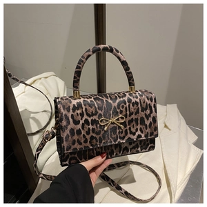 Close-up of leopard print shoulder bag featuring a golden bow buckle and fine PU leather