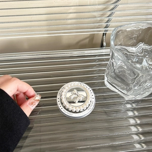 Macro detail of a pearl phone grip with mirror finish and 3D silver bow accent