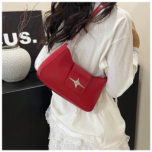 Gros plan d'un sac baguette rouge en similicuir avec boucle étoile argentée sur modèle