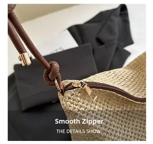 Detail of woven beach tote showing smooth brown zipper and knotted faux leather strap
