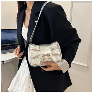 Detail of silver metallic shoulder bag with large bow buckle and pleated accents