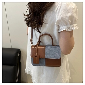 Detailed side view of textured patchwork crossbody bag with stylish leather hangtag