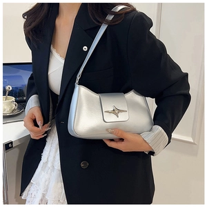 Sac sous le bras chic en métal argenté avec boucle étoile dans un bureau moderne
