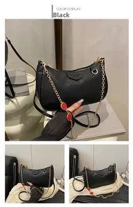 Detail of black lychee grain bag with gold chain and red strawberry charms