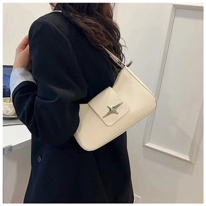 Détail du sac sous l'aisselle beige avec boucle étoile argentée porté par le mannequin
