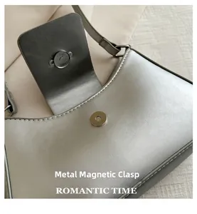 Detail shot of the secure silver hardware magnetic clasp on the silver shoulder bag