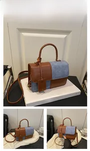 Detail view of stylish brown leather and blue denim patchwork handbag for daily commuting