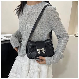 Détail du sac bandoulière noir avec nœud papillon argenté et plis en cuir PU de qualité