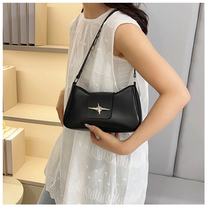 Détail de la boucle étoile argentée sur le sac baguette en cuir noir mat élégant