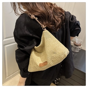 Detailed close-up of woven beige tote bag featuring a leather Fashion tag and knotted strap