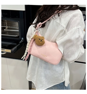 Roze PU-lederen hobo tas met beertje hanger en gevlochten riem op de schouder