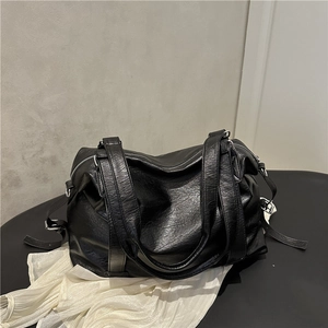 Minimalist black leather tote bag with dual handles and large capacity on display