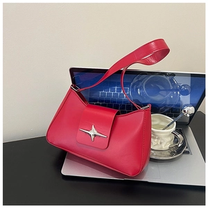Détail du sac baguette en cuir rouge avec fermoir étoile en argent et bandoulière chic