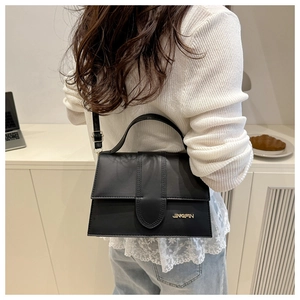 Bolso bandolera cuadrado de cuero negro en modelo para mostrar tamaño real y estilo