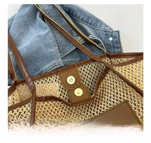 Close-up of woven tote bag with brown leather trim and golden magnetic closure buckle