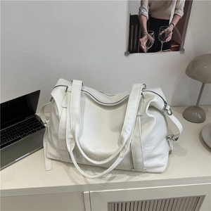Large white faux leather travel tote bag with double handles and adjustable shoulder strap