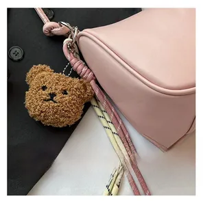 Roze halve maan tas met touwdetails en een schattige pluche beer hanger