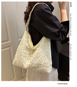 Gros plan du motif en dentelle florale au crochet et détails sur le sac beige