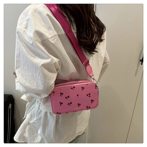 Pink crossbody bag with cherry prints and adjustable nylon shoulder strap
