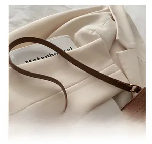 Detail of dark brown retro shoulder bag with bronze metal ring and suede texture