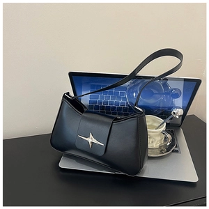 Détail d'un sac sous les aisselles en cuir noir avec boucle étoile argentée et café