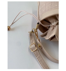 Détails de sac en toile beige avec broderie florale et ferrures dorées