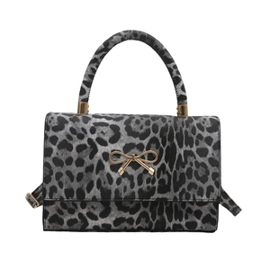 Leopard print crossbody bag with gold bow buckle and top handle in rectangle shape