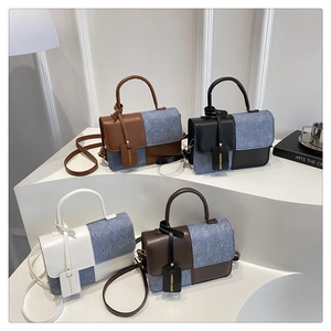 Group shot of four contrast color denim and leather flap handbags on display
