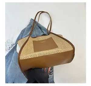 Macro view showing the wide sturdy base and leather stitching of the woven tote bag
