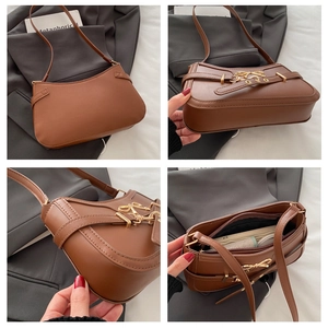 Macro shot of brown faux leather shoulder bag featuring gold bow buckle and inner pocket