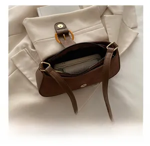 Top view of deep brown suede shoulder bag showing interior storage and gold hardware