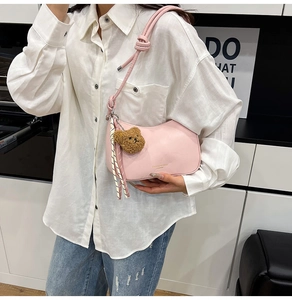 Pink half-moon shoulder bag with knot strap and plush bear charm decoration
