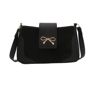 Minimalist black crossbody bag with gold bow lock and wide strap on white background