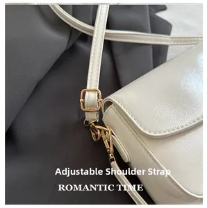 Détail de la bandoulière réglable et texture cuir sur un sac à bandoulière blanc