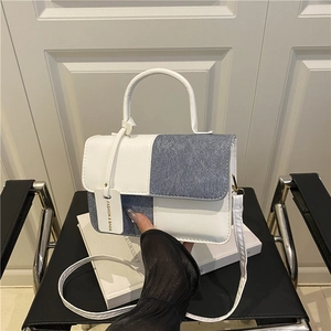Fashionable contrast patchwork crossbody bag with top handle and blue denim texture