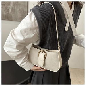Detail of canvas and leather underarm bag with a vintage bronze metal buckle on the front
