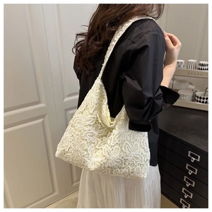 Gros plan sur la broderie florale en dentelle beige d'un grand sac cabas avec texture