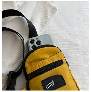 Détail du sac à bandoulière jaune montrant la capacité intérieure avec un smartphone