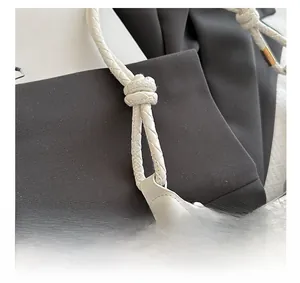 Macro detail of white woven leather texture and knotted shoulder strap on crescent bag