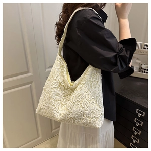 Détail du motif floral en dentelle au crochet sur un sac fourre-tout crème élégant et chic
