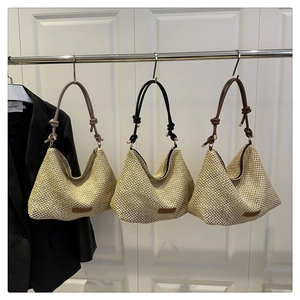 Detailed texture of handwoven hobo straw bags with knotted straps in various colors