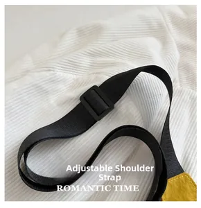 Détail de la bandoulière tissée noire réglable et de la boucle sur un sac jaune vif