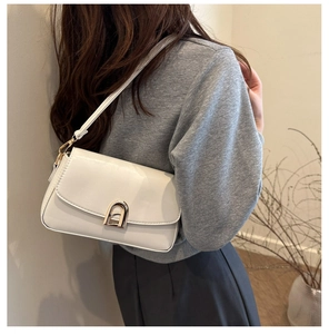 Détail d'un sac à bandoulière blanc de luxe avec cuir texturé et fermoir en métal doré