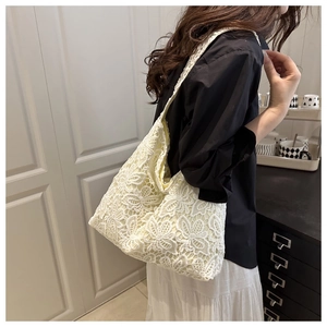 Gros plan détaillé des motifs de fleurs en dentelle et de la texture de ce sac cabas